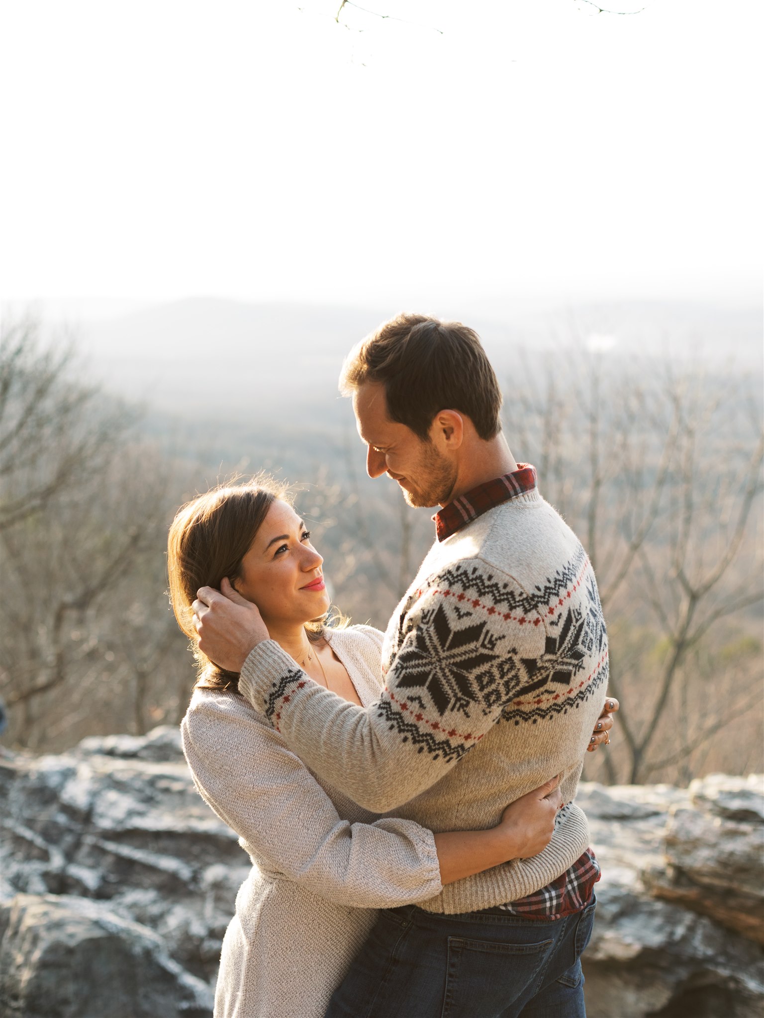 groom pushes bride's hair back during winter engagement session