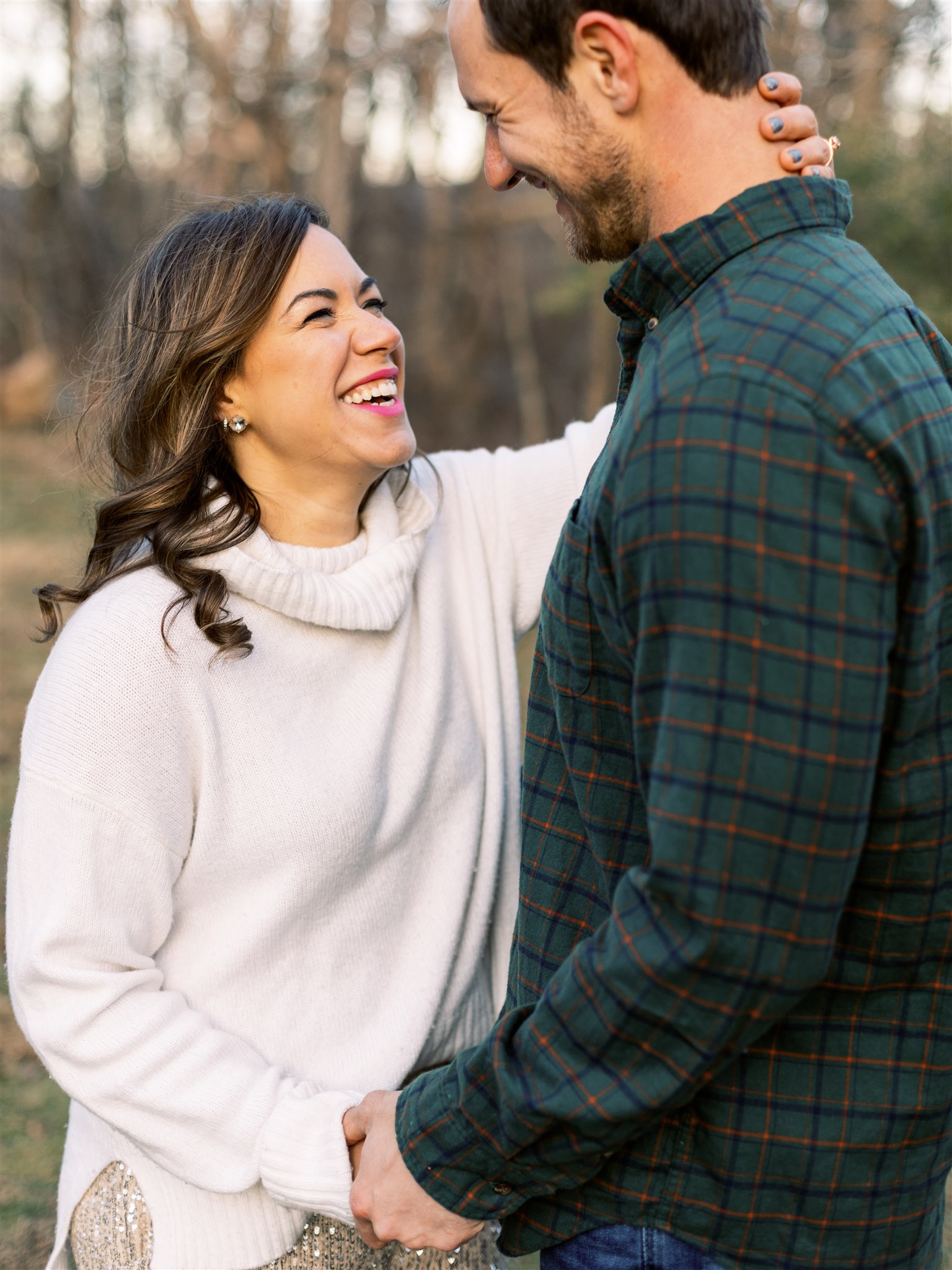 engaged couple laughs during Christmas inspired winter engagement session