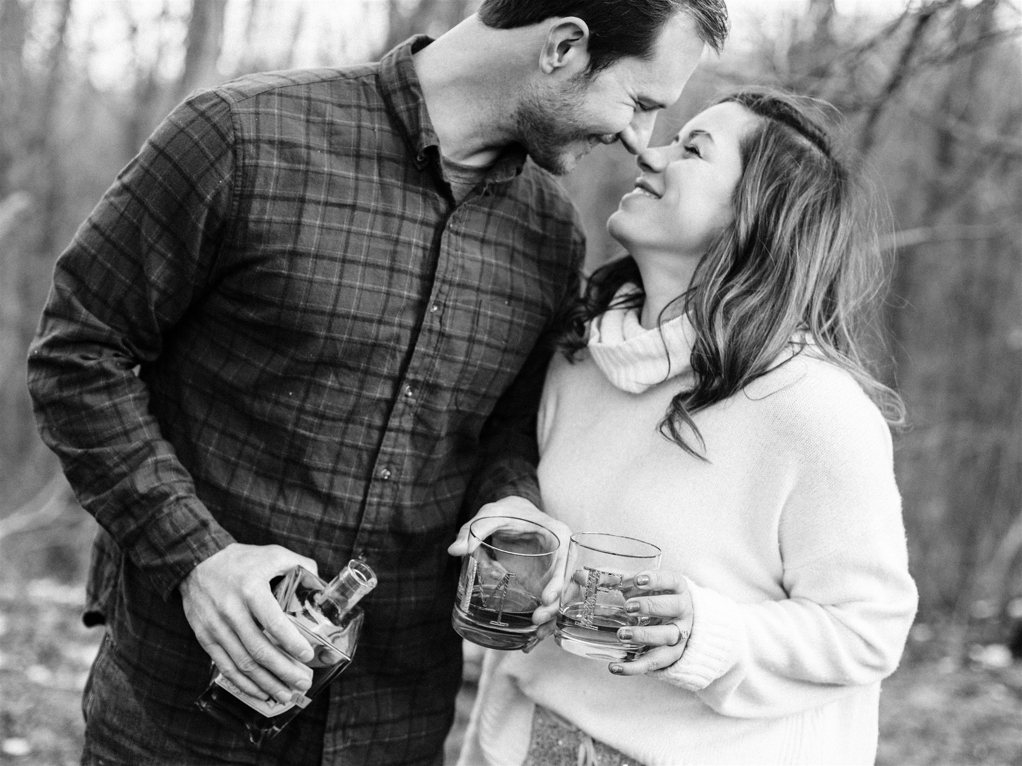 engaged couple toasts upcoming wedding with whiskey