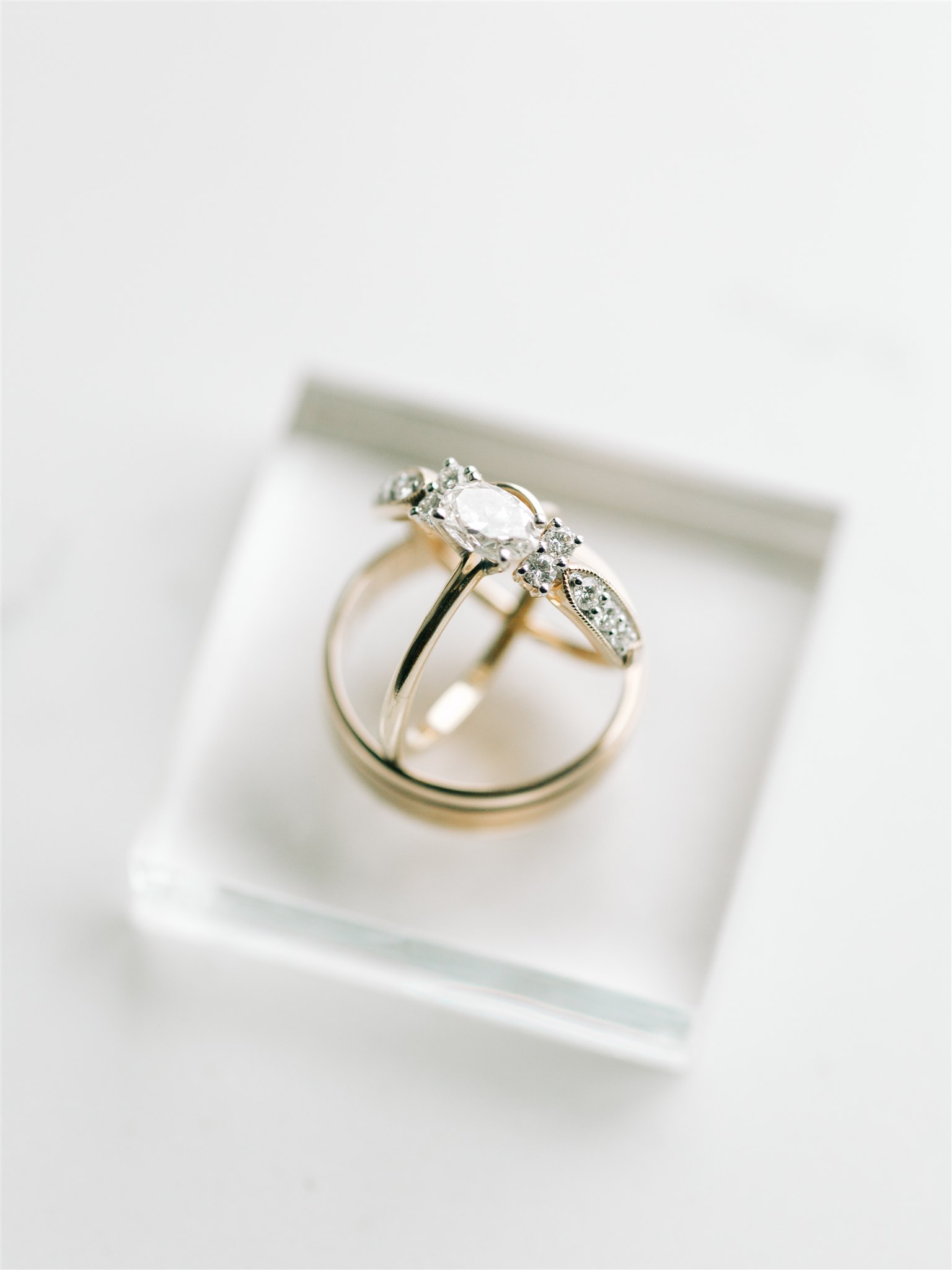 bride's gold ring sits on clear ring box