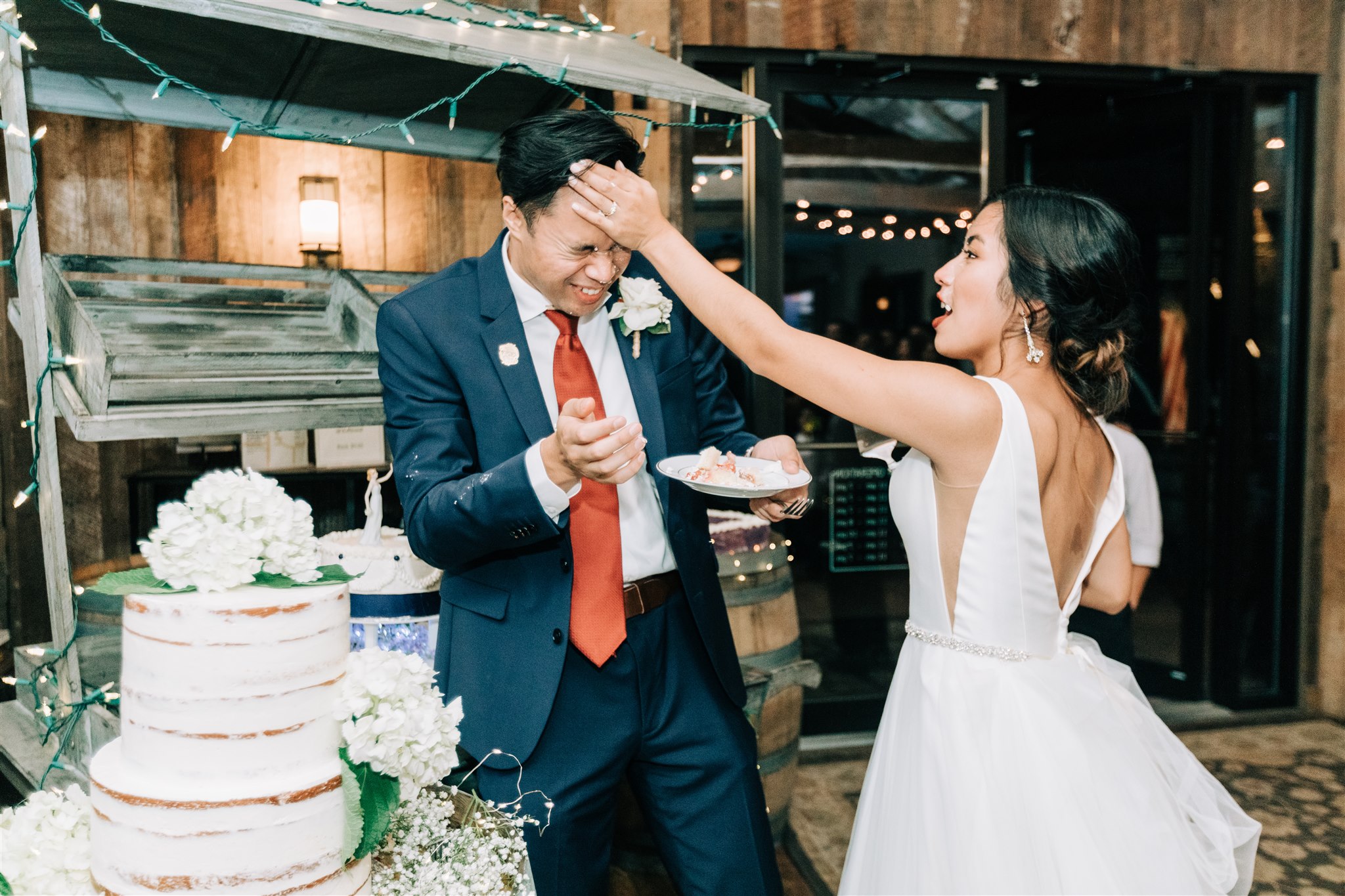 bride smears wedding cake in groom's face