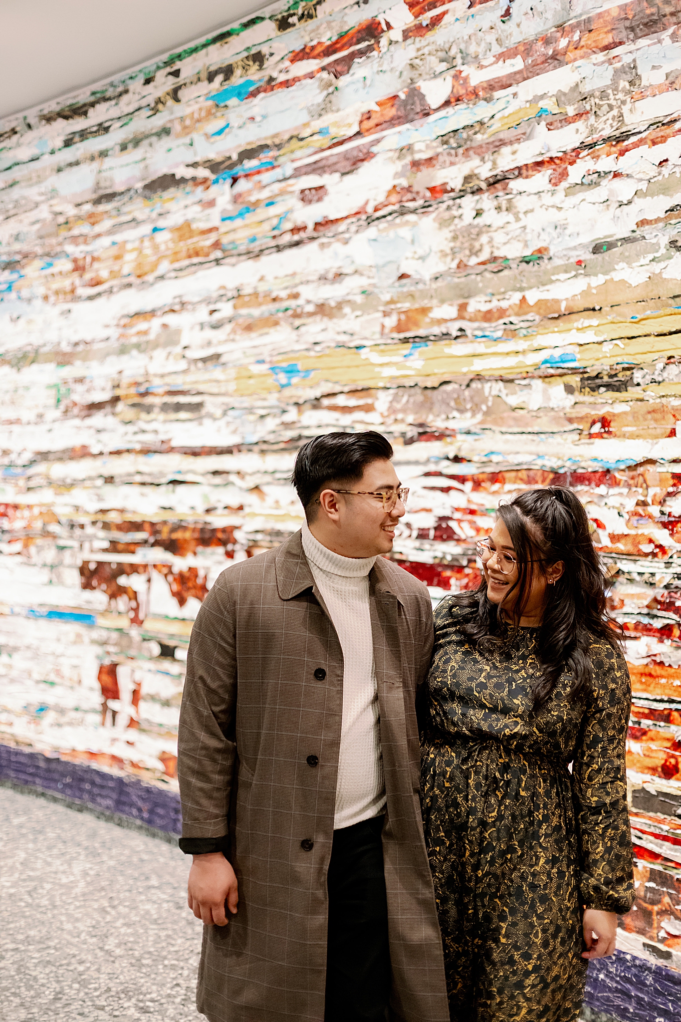 engage couple walks through display of modern art