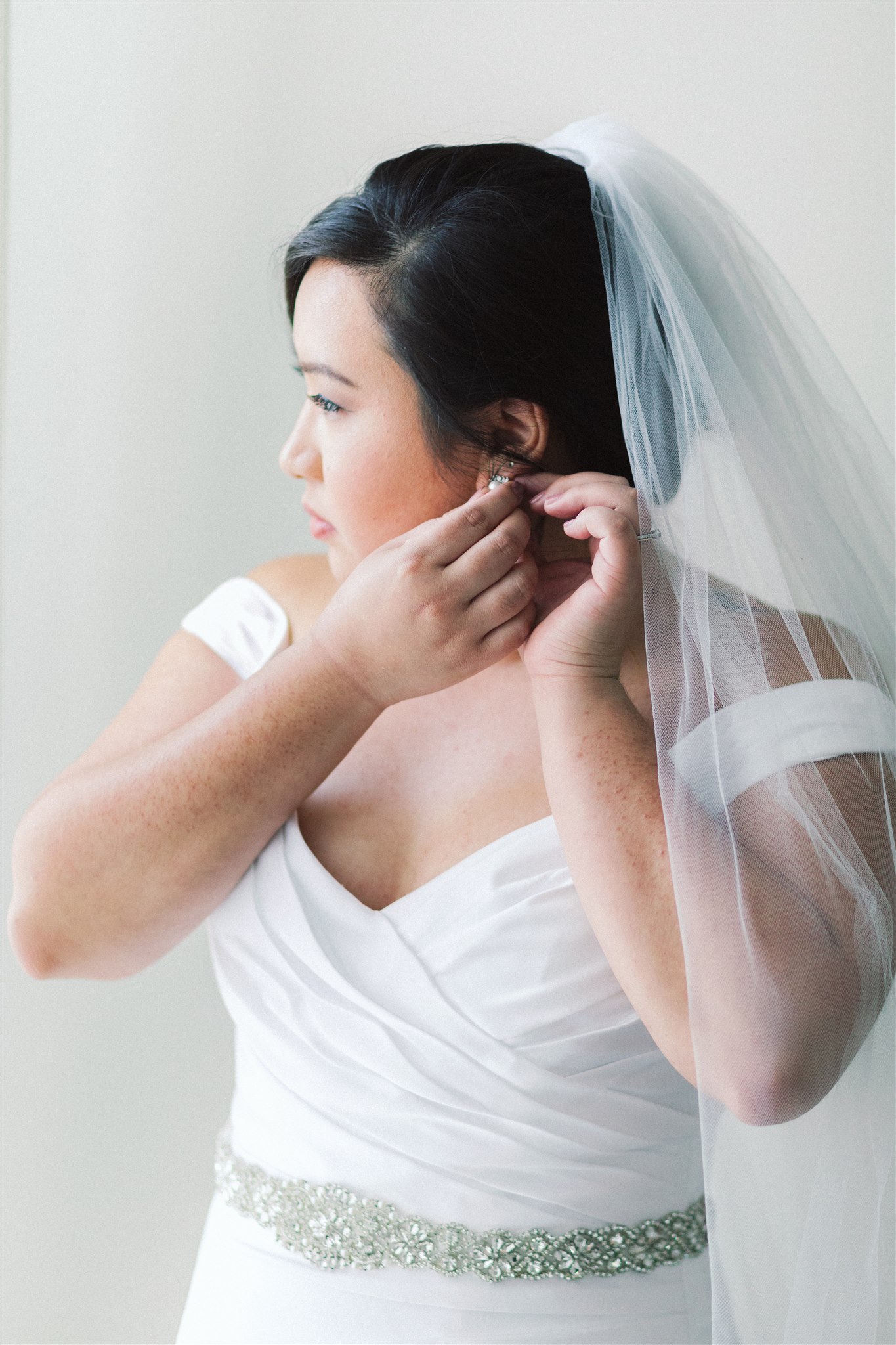 bride adjusts earrings before Norfolk VA Wedding