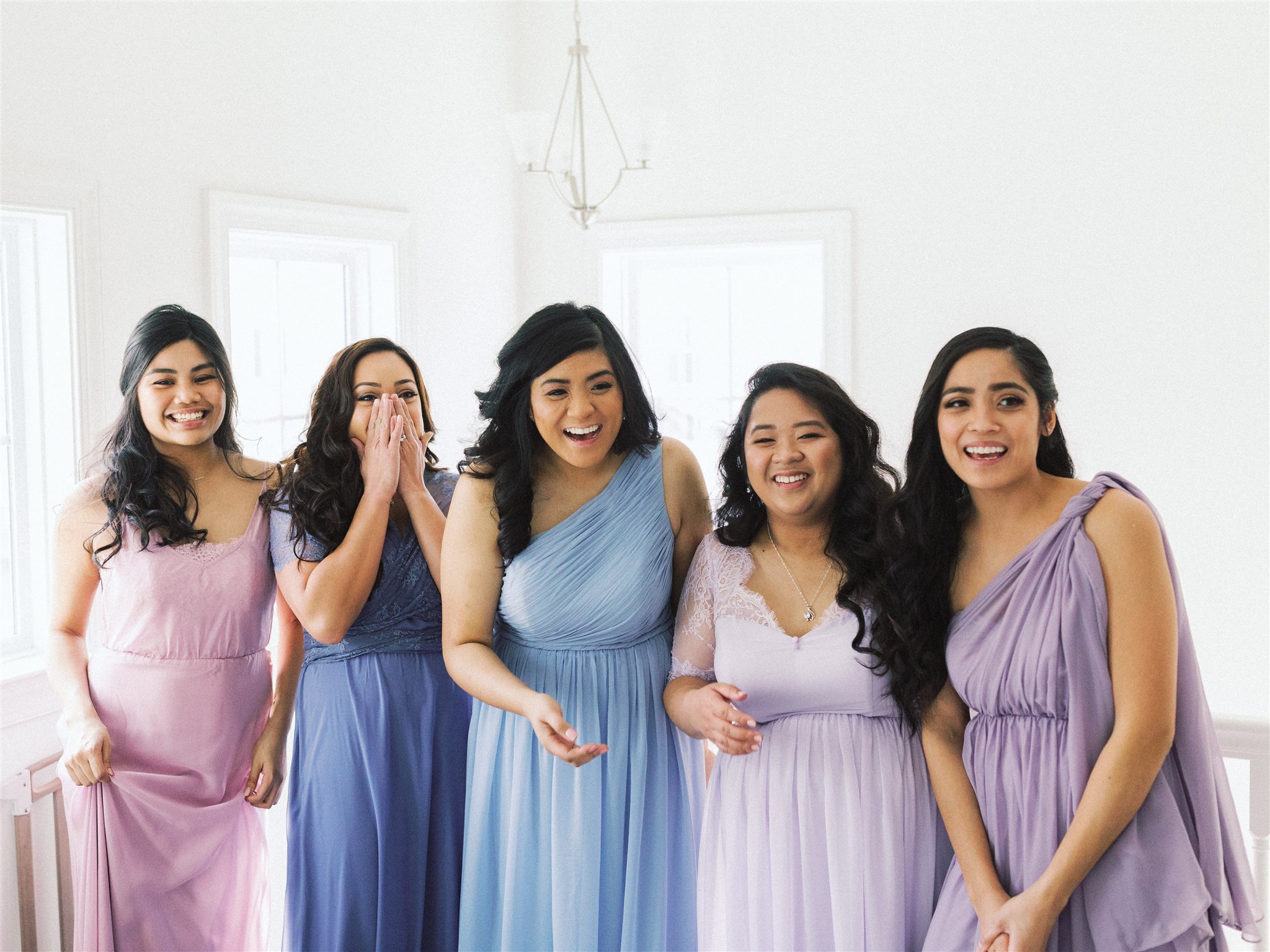 bridesmaids smile at bride's classic look during first look