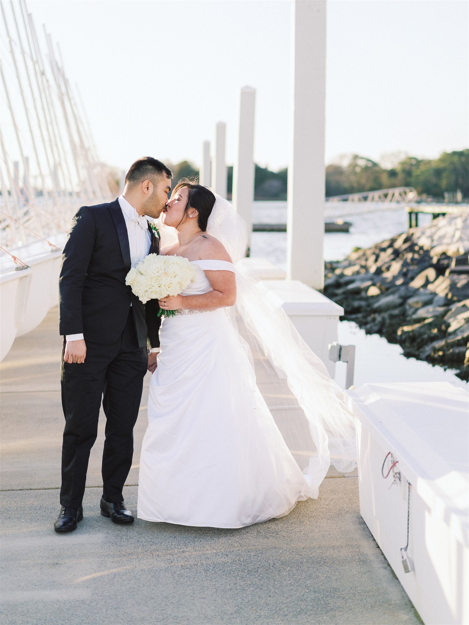 bride and groom kiss on dock