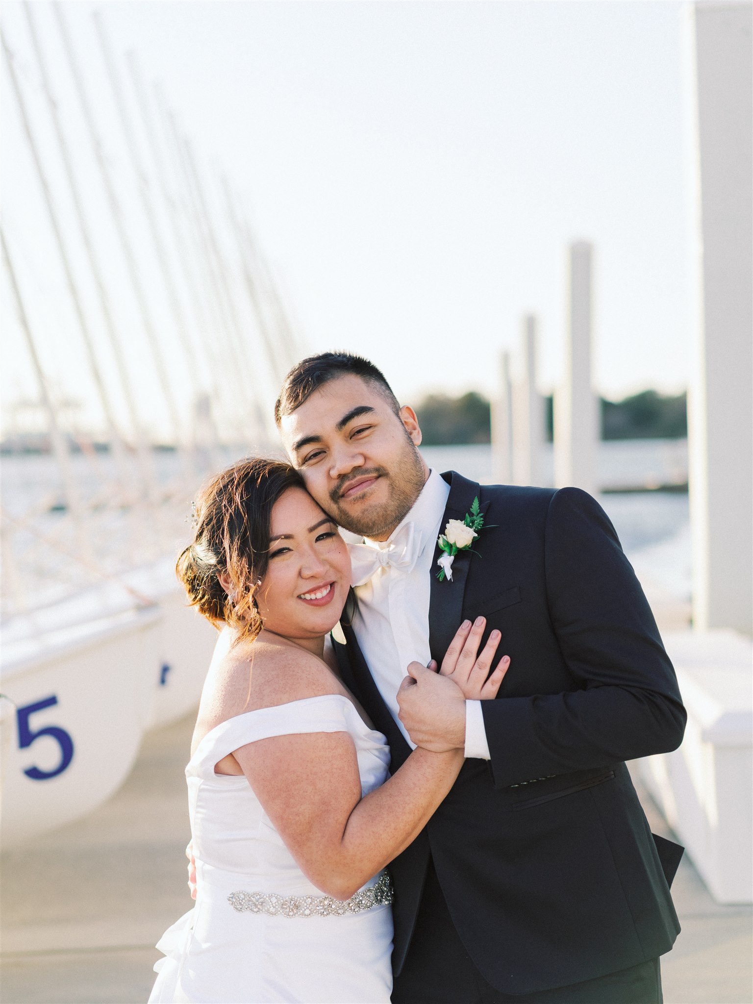 bride and groom pose on dock in Norfolk VA