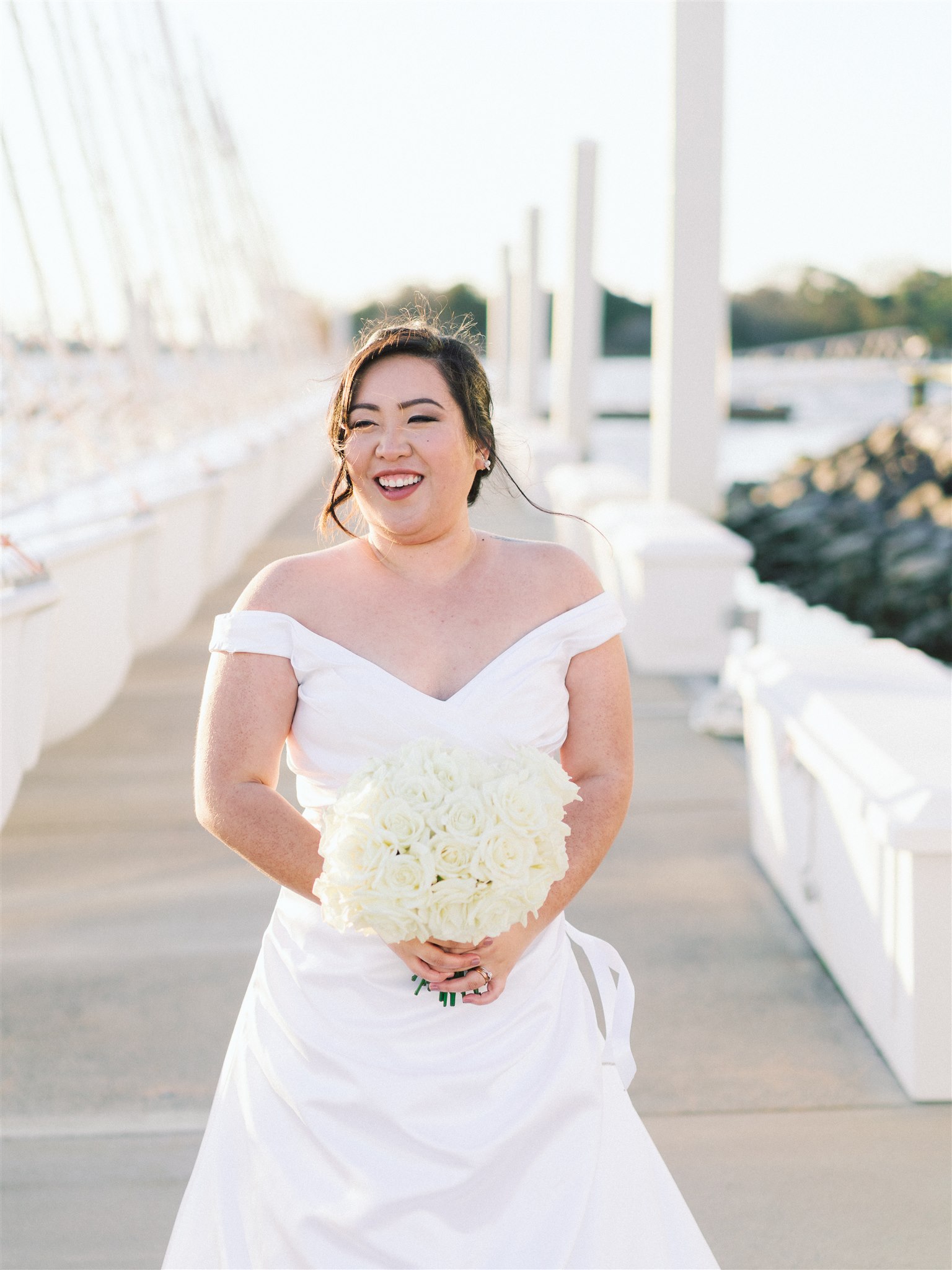 bride holds bouquet of all-white flowers