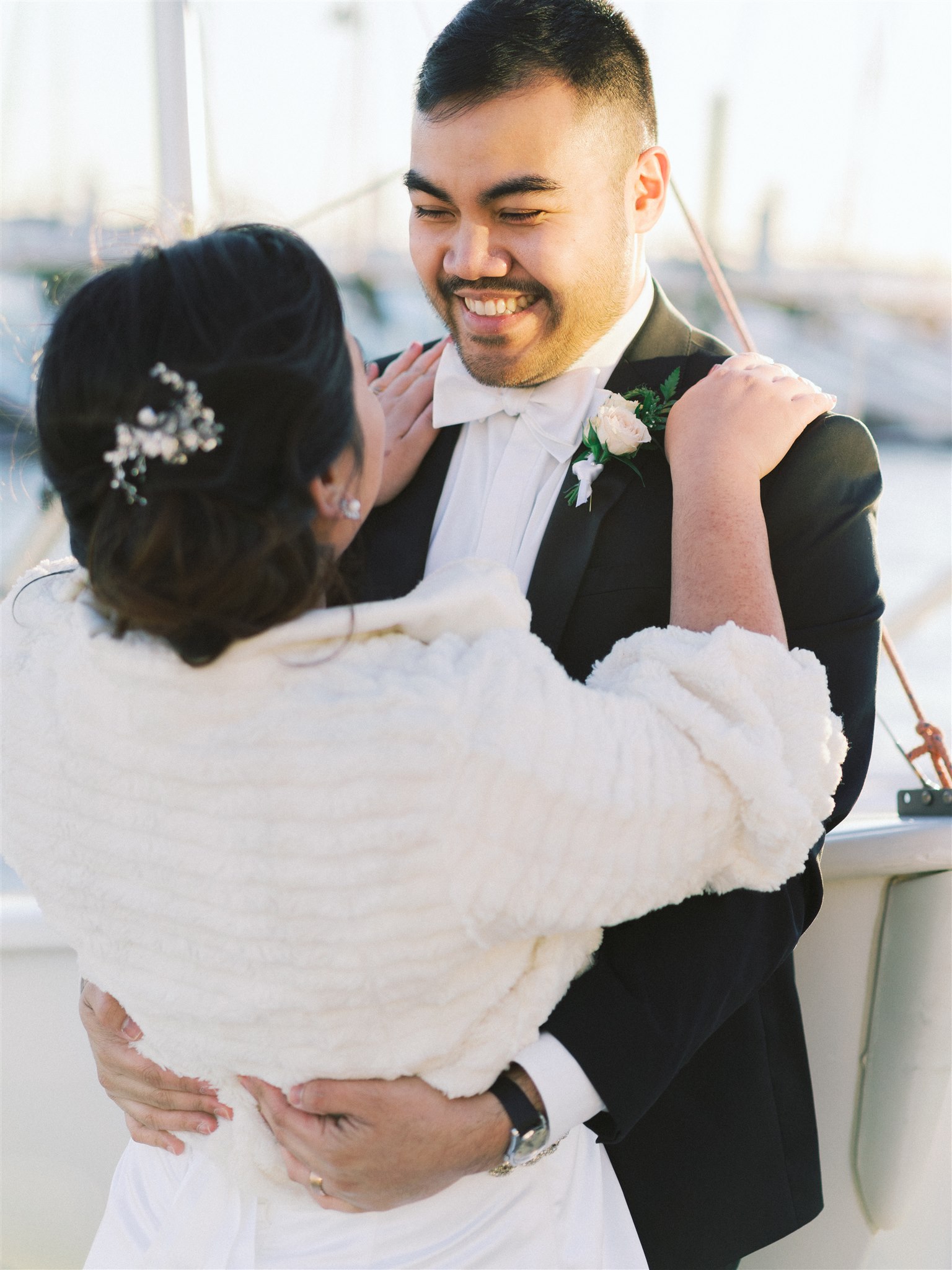 bride in ivory fur hugs groom during Norfolk VA photos