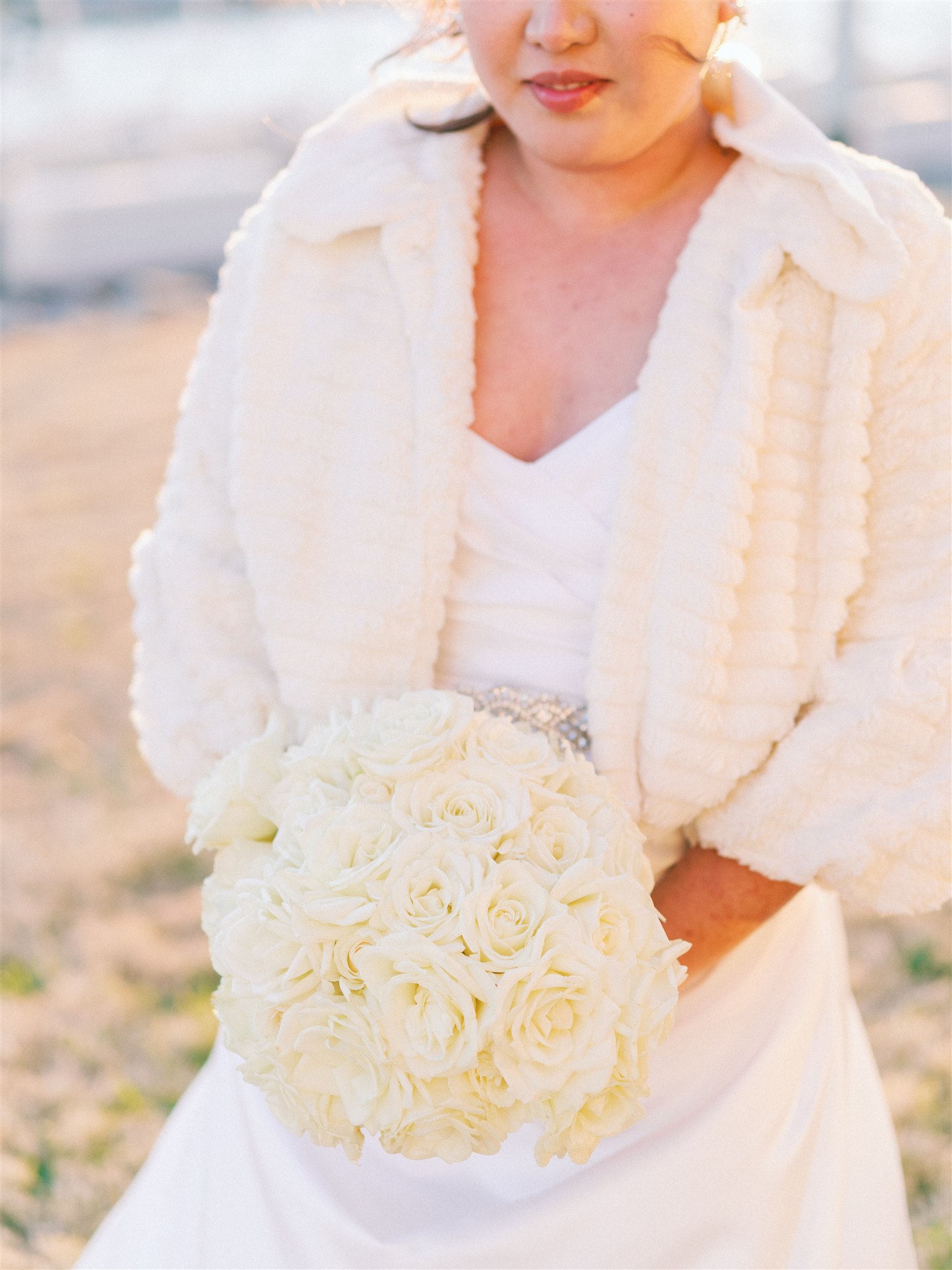 bride holds bouquet of ivory flowers