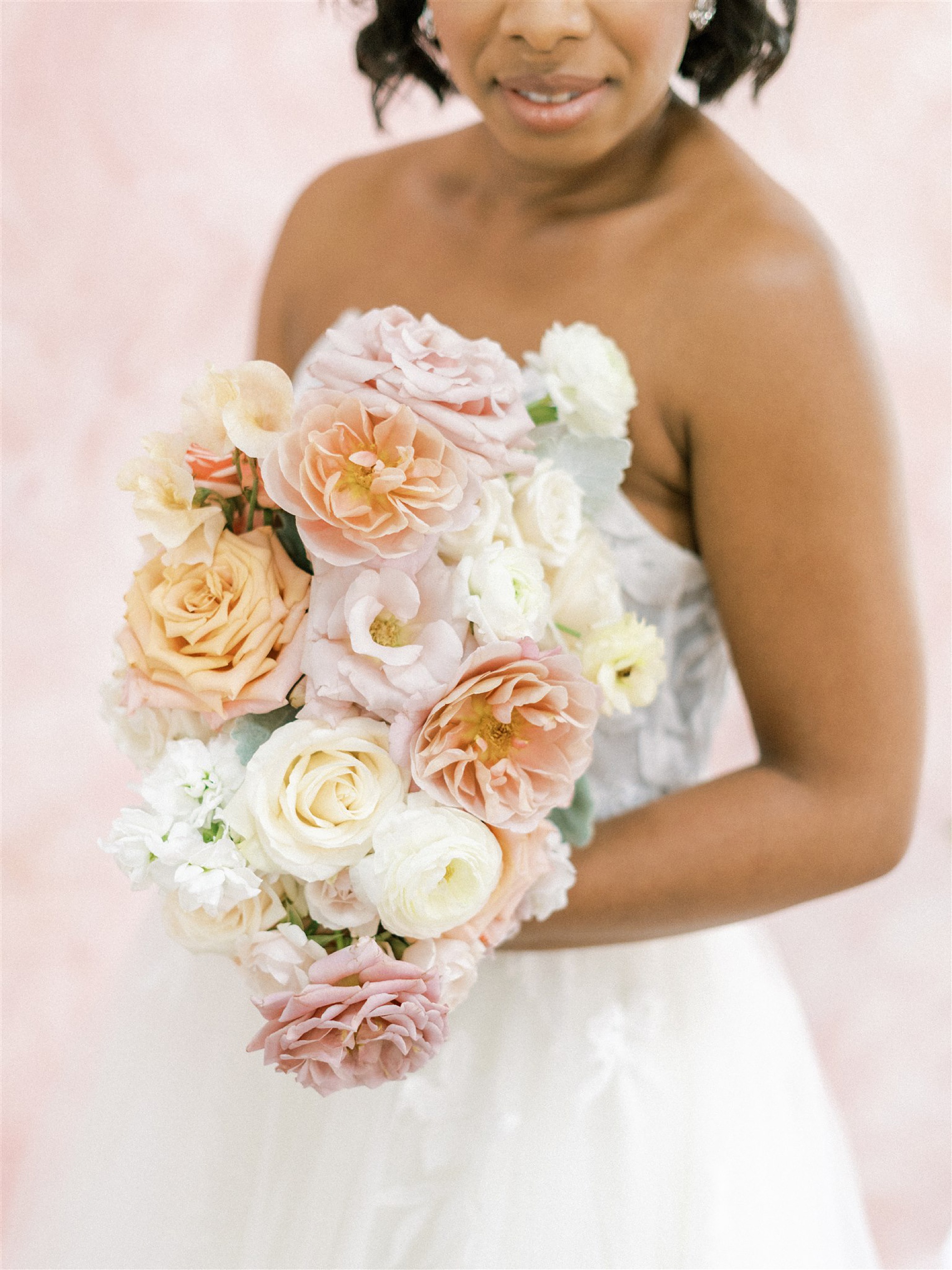 bride holds bouquet with pastel and ivory flowers