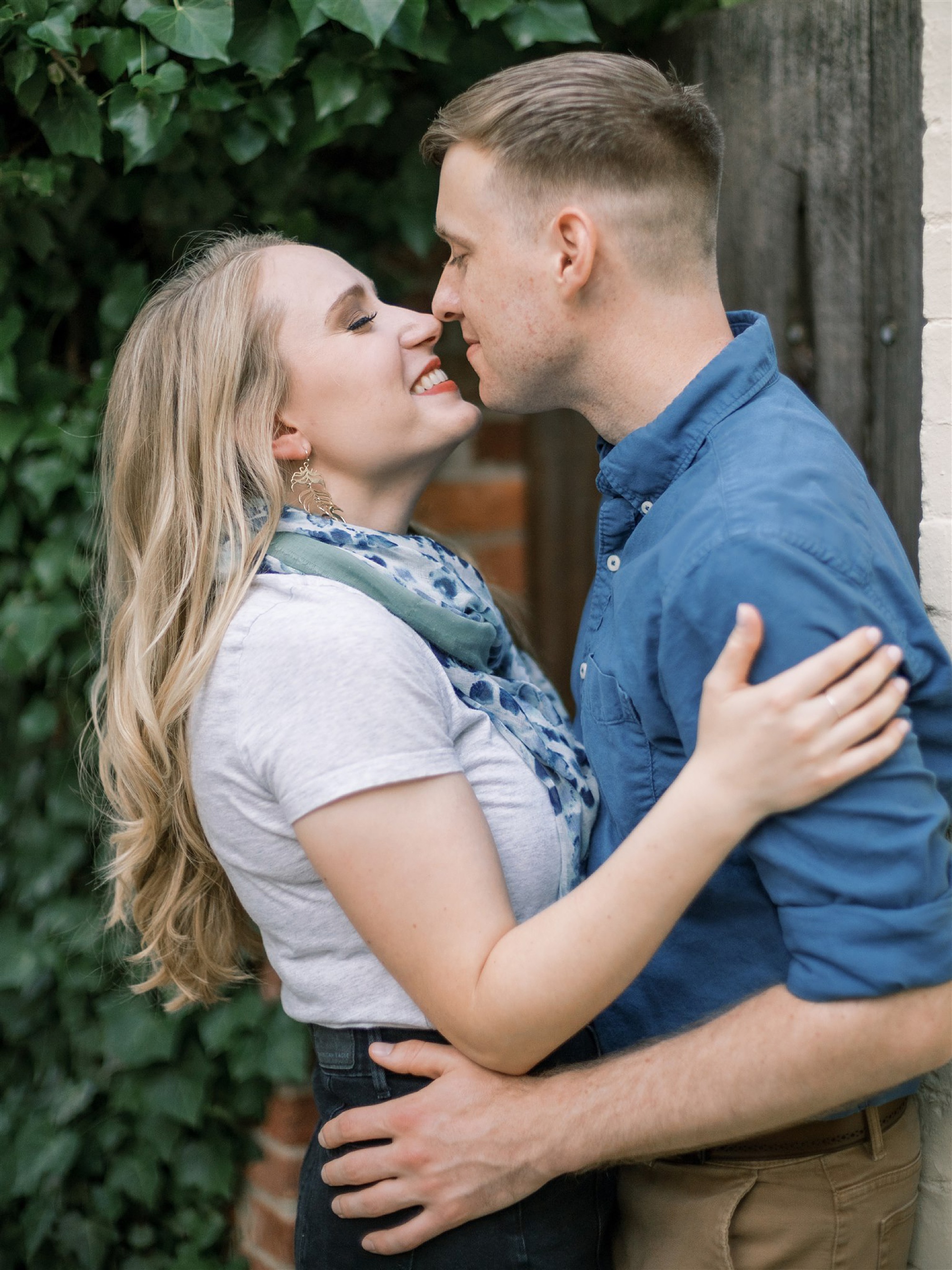 engaged couple stands nose to nose during Old Town Alexandria engagement session