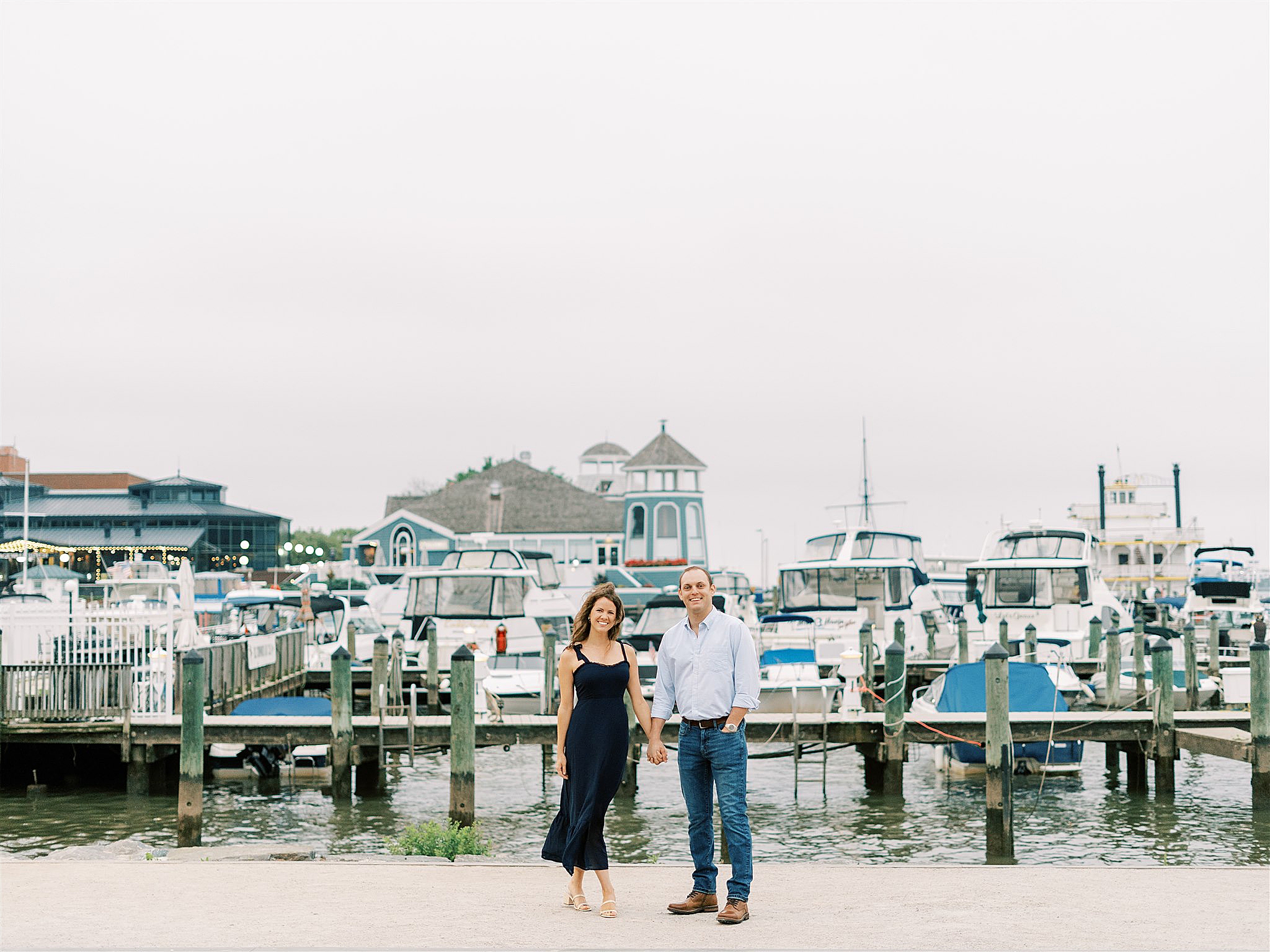 bride and groom pose by waterfront in Old Town Alexandria