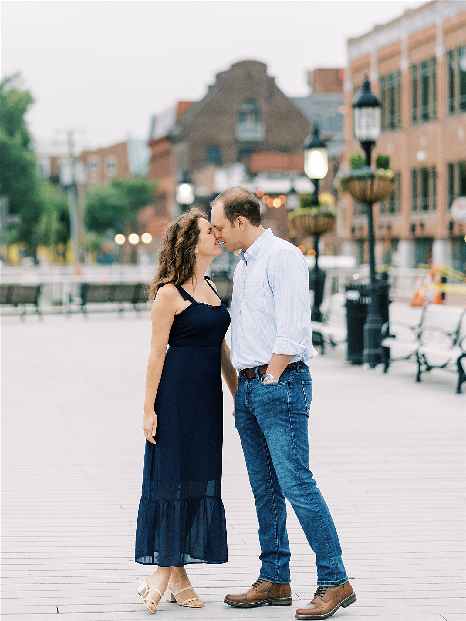 bride and groom stand nose to nose during engagement session