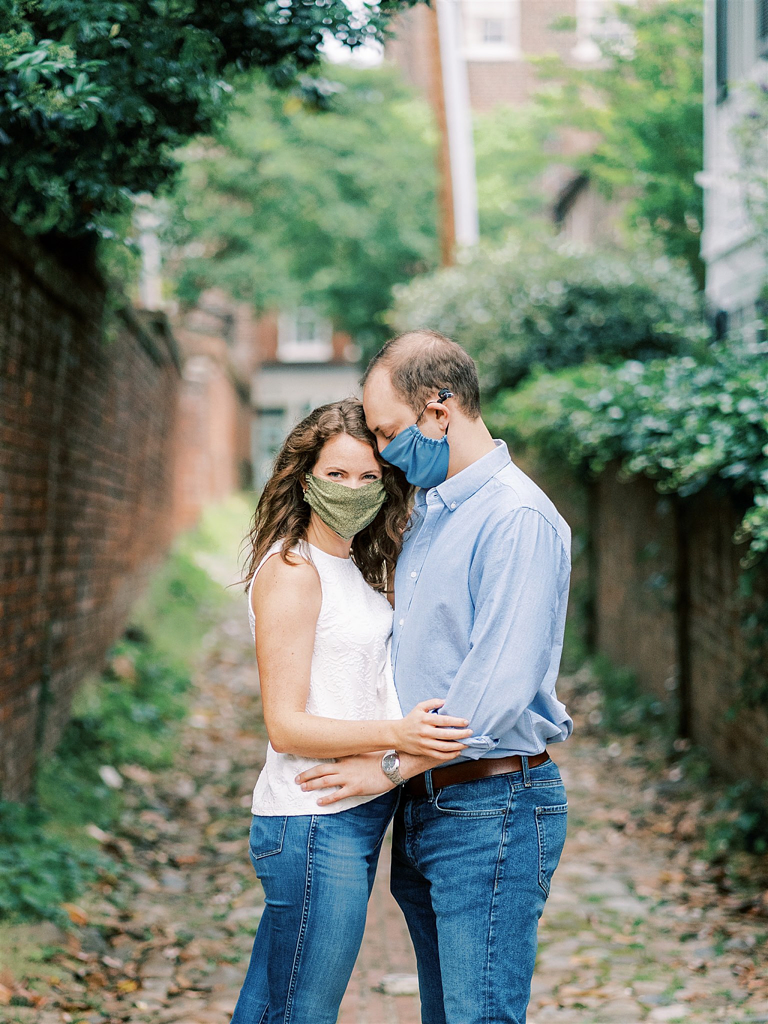 engaged couple in masks poses in alleyway of NOVA