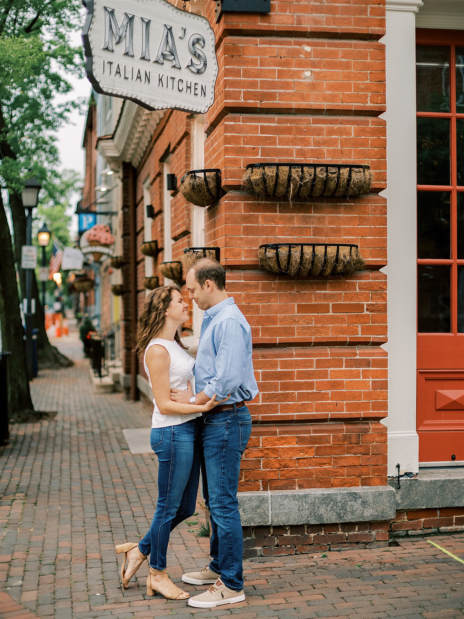 engaged couple poses by Mia's Italian Kitchen in Old Town Alexandria