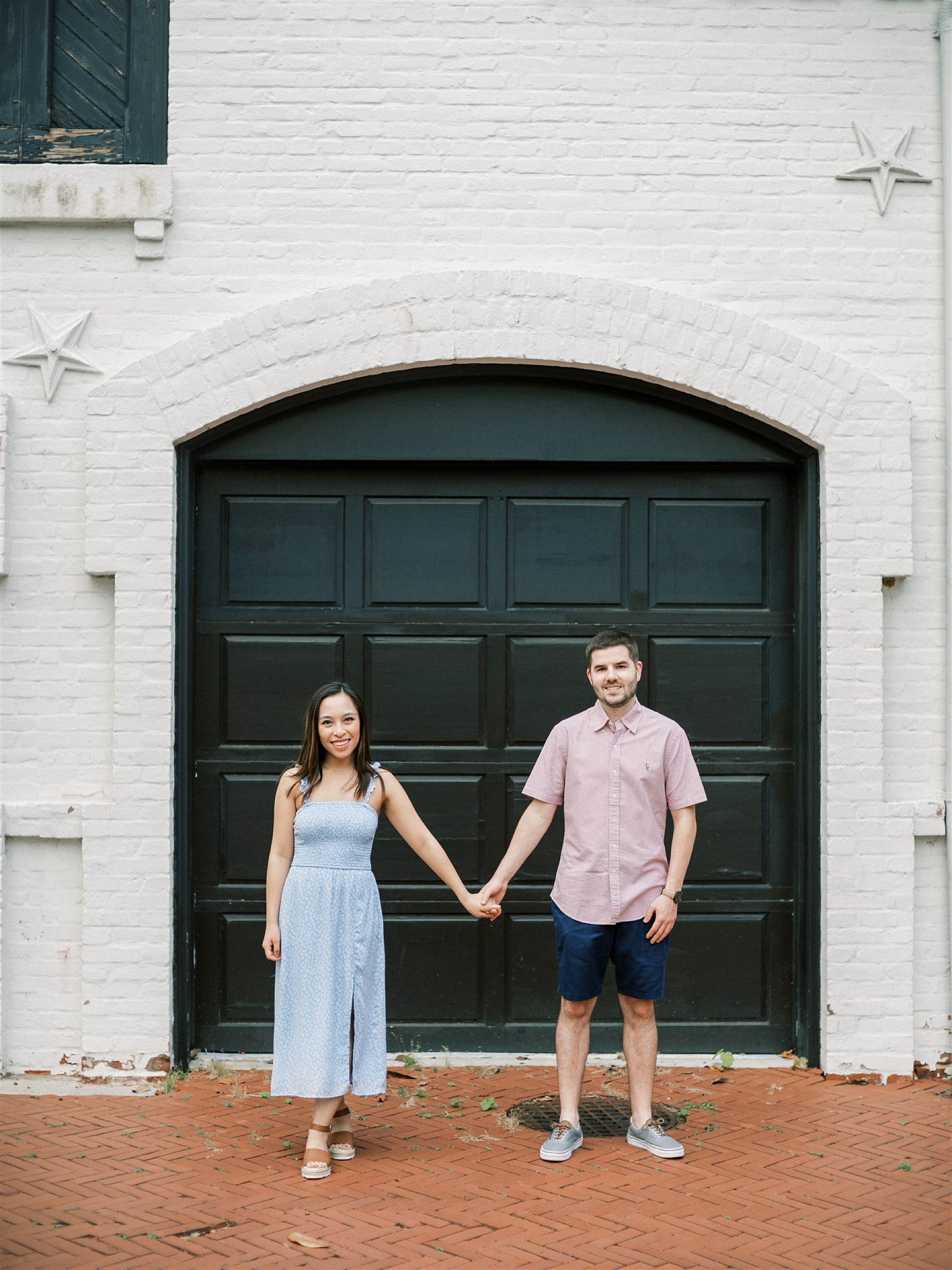 engaged couple holds hands by garage door in Georgetown