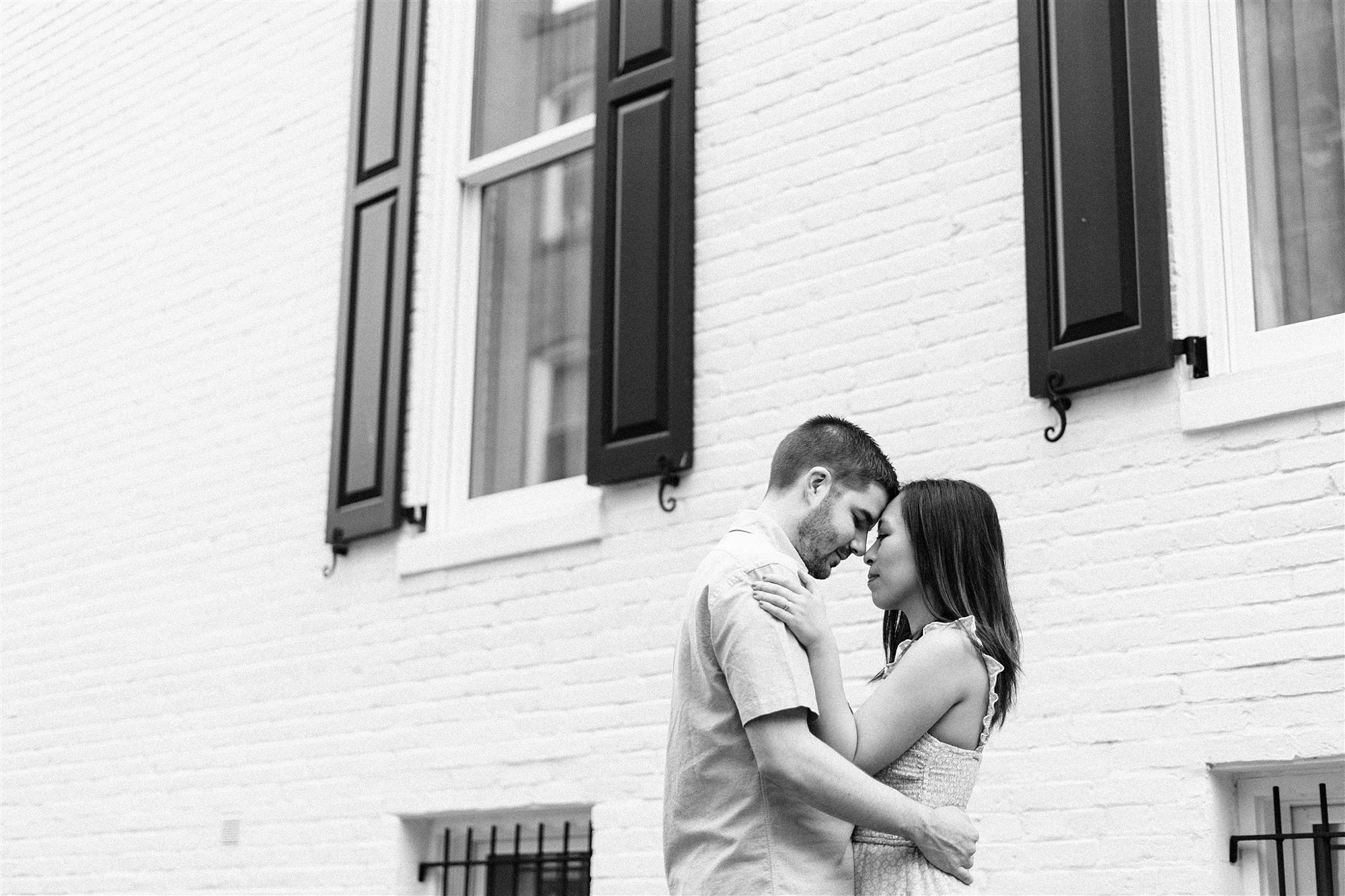 bride and groom pose by building in Georgetown DC