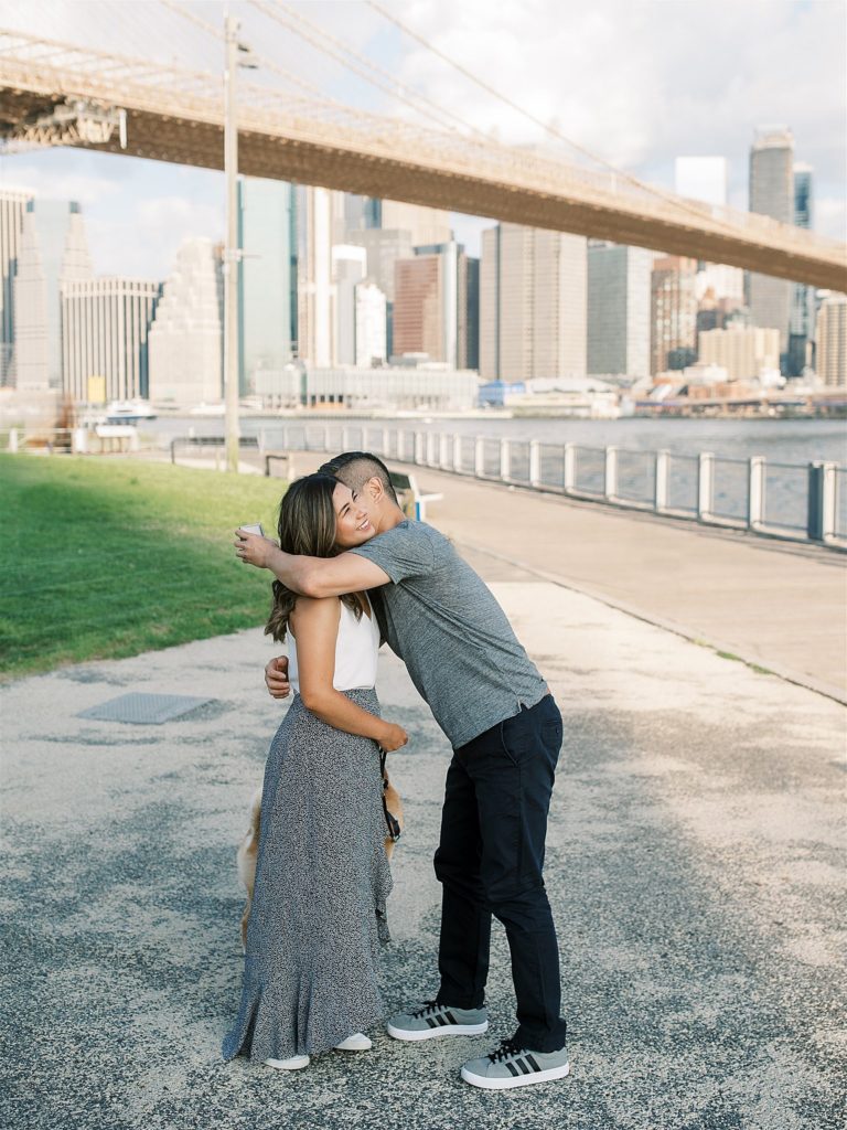 bride and groom hug after proposal in Brooklyn Bridge Park