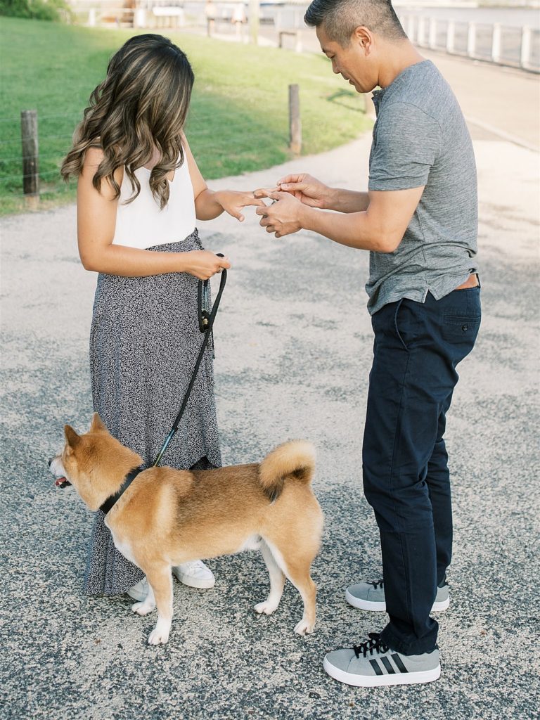 groom slips ring on bride's finger after surprise NYC proposal