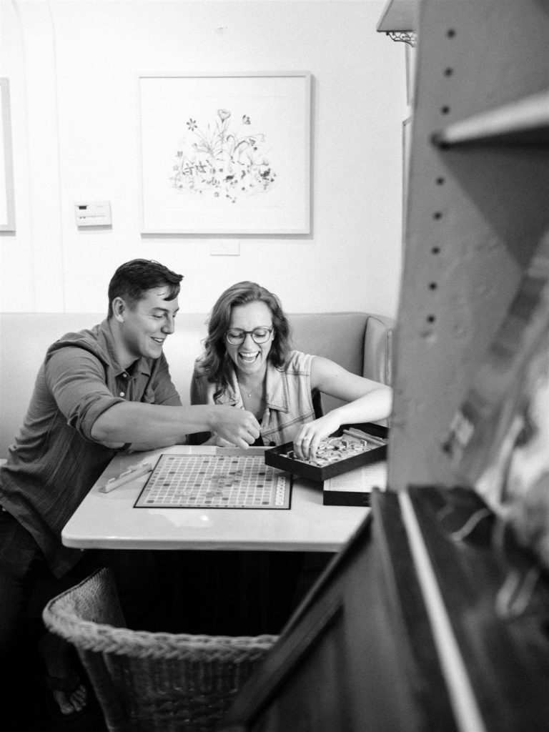 engaged couple plays Scrabble during photos at Trinity House Cafe