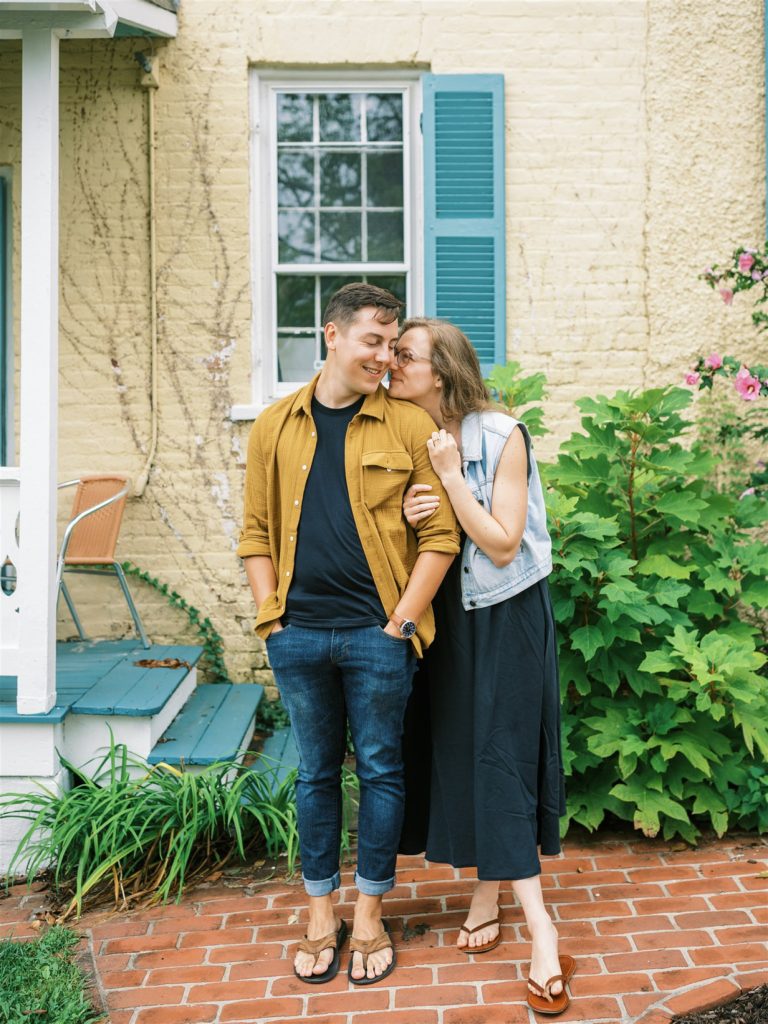 bride nuzzles back of groom's neck during downtown Leesburg engagement session