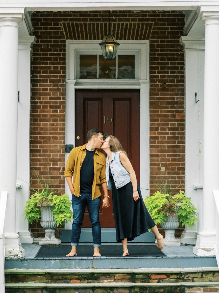 engaged couple poses on front steps of home in downtown Leesburg