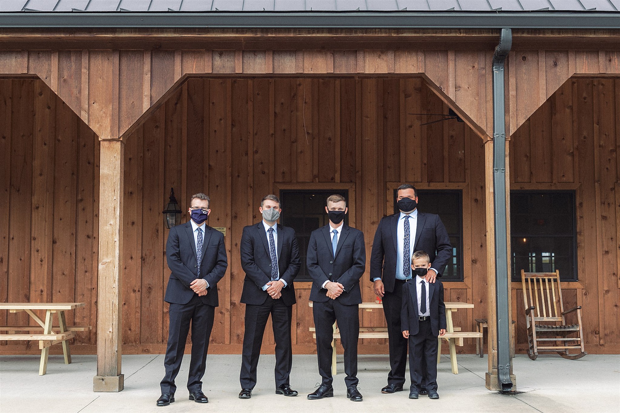 groom poses with groomsmen and ring bearer in masks