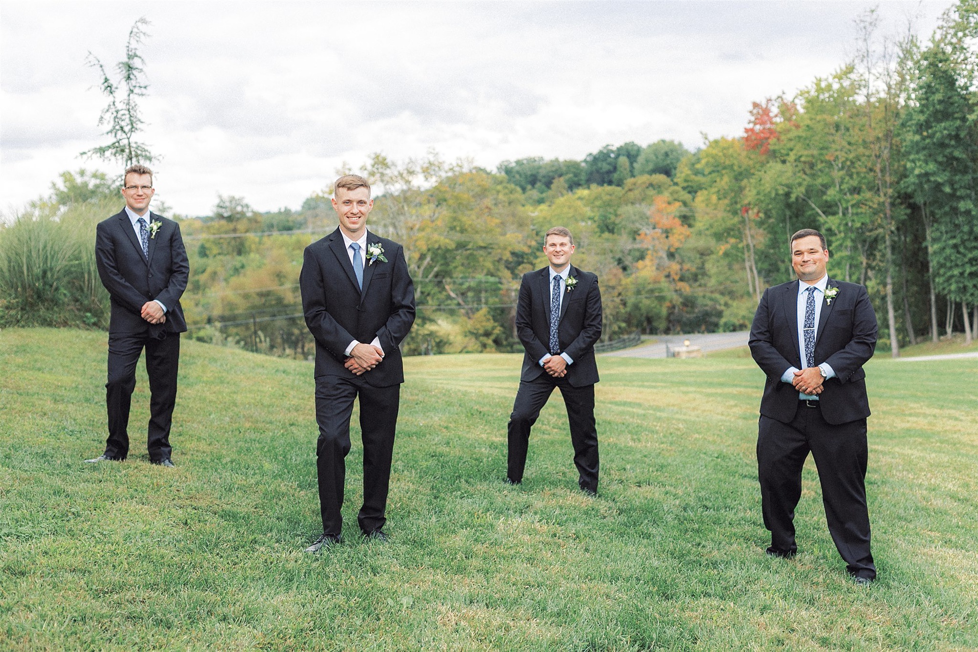 groom and groomsmen pose on hill at Mt Defiance Cidery
