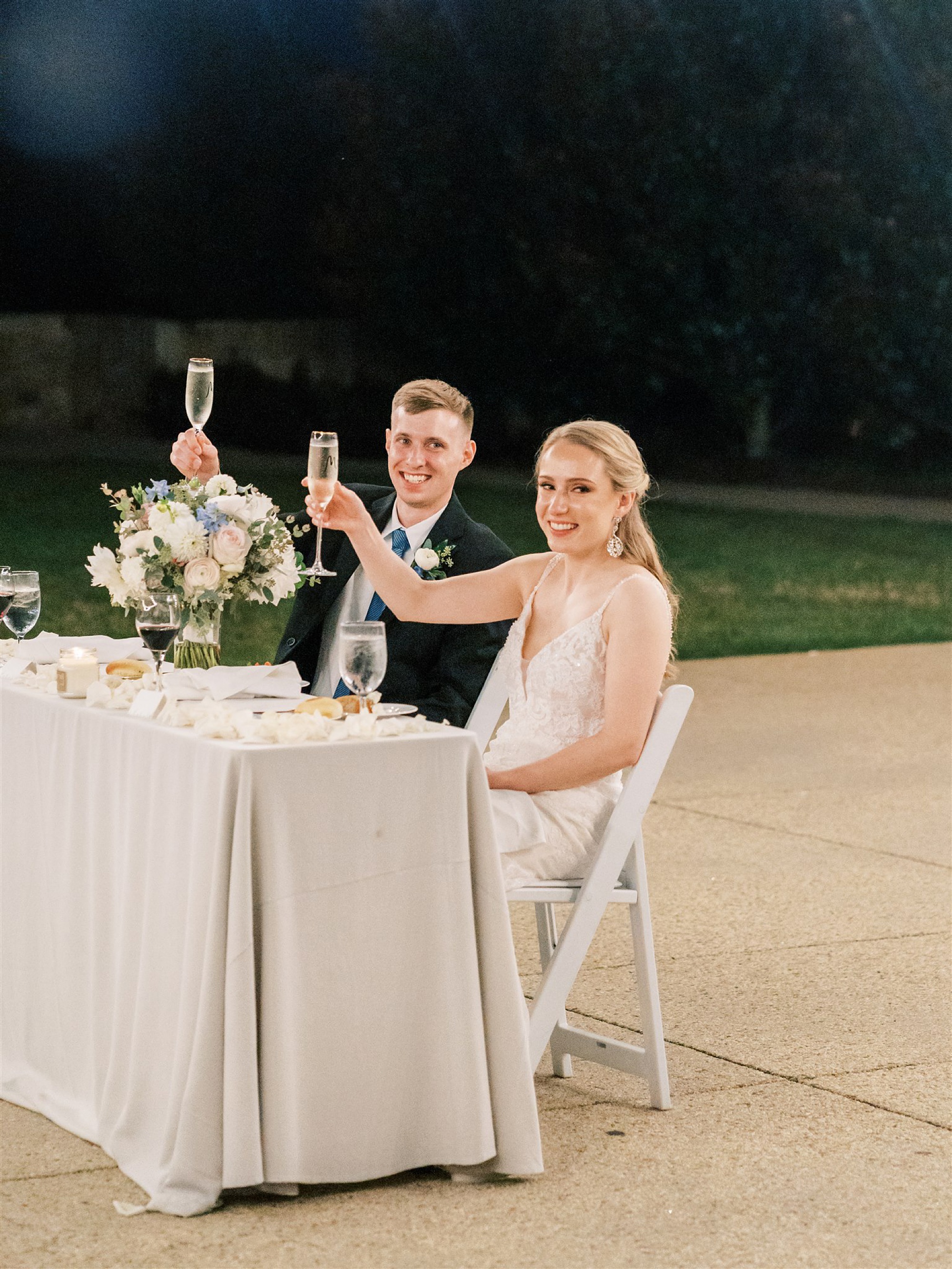 newlyweds lift glasses during reception for fall wedding