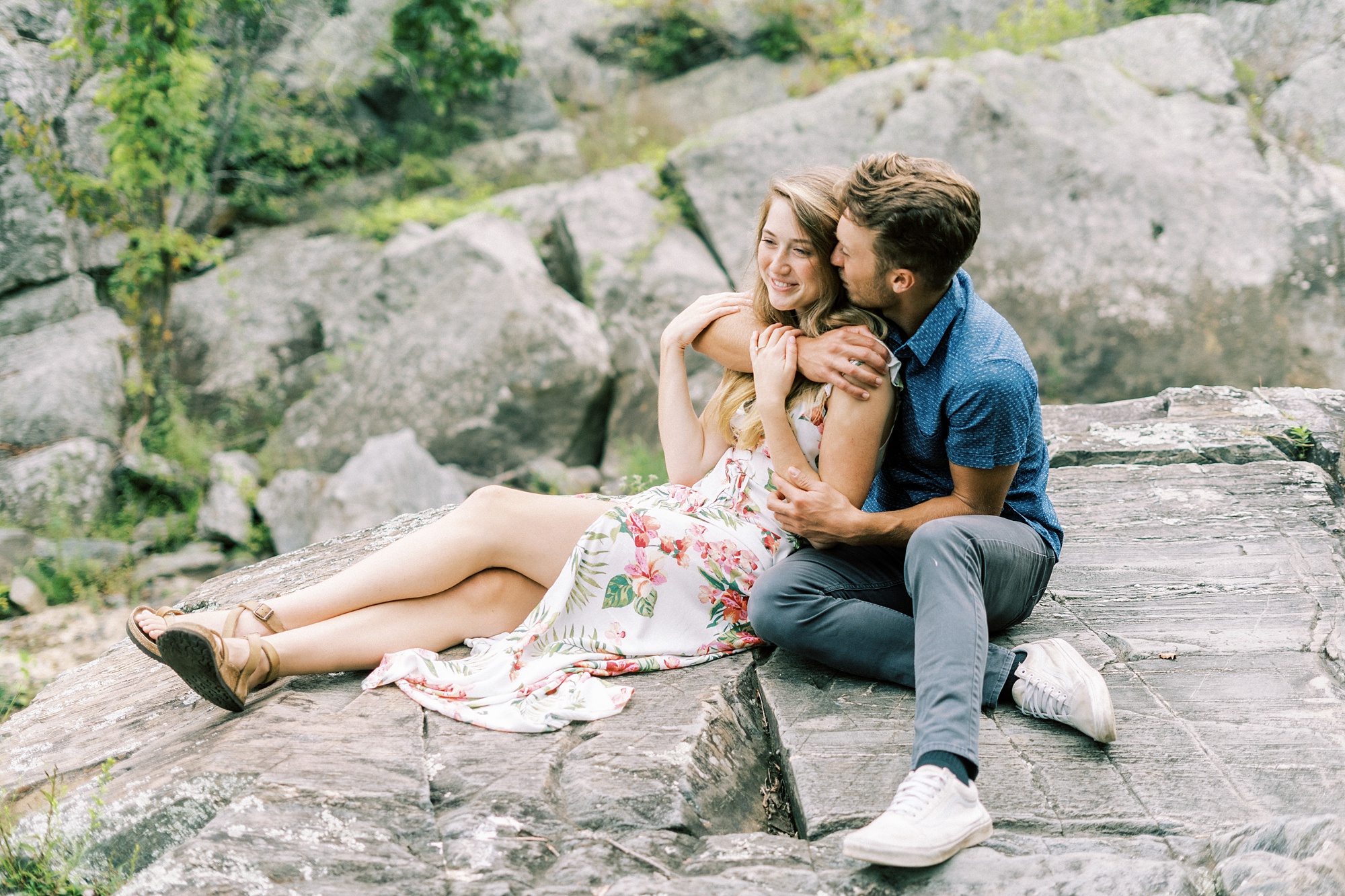 engaged couple sits on rocks at Great Falls Park