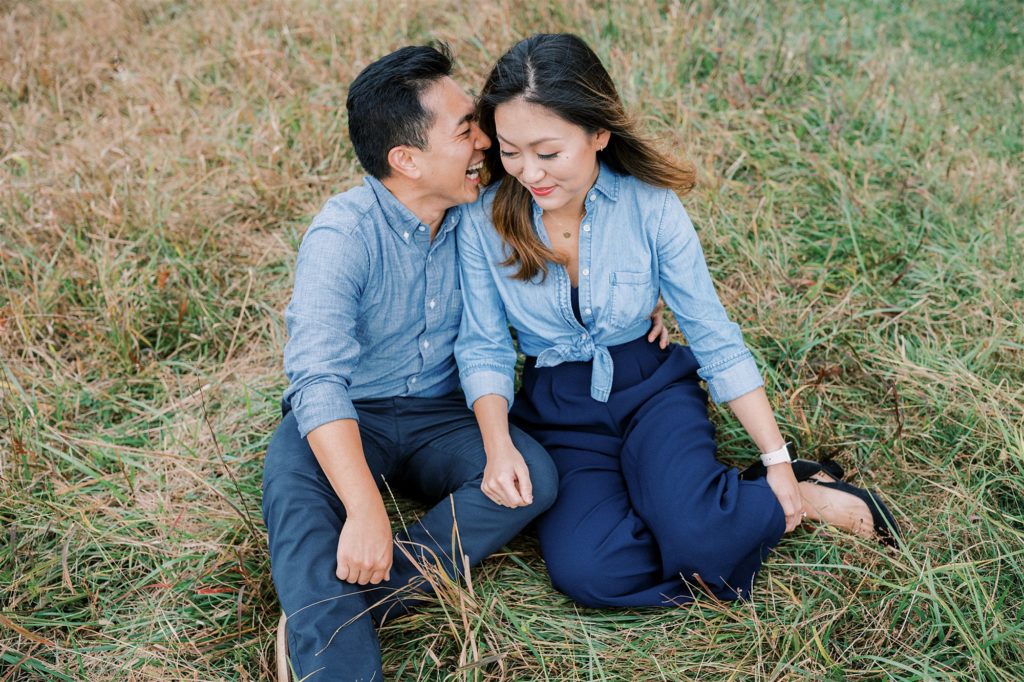 groom whispers in bride's ear during fall engagement session at Manassas Battlefield Park