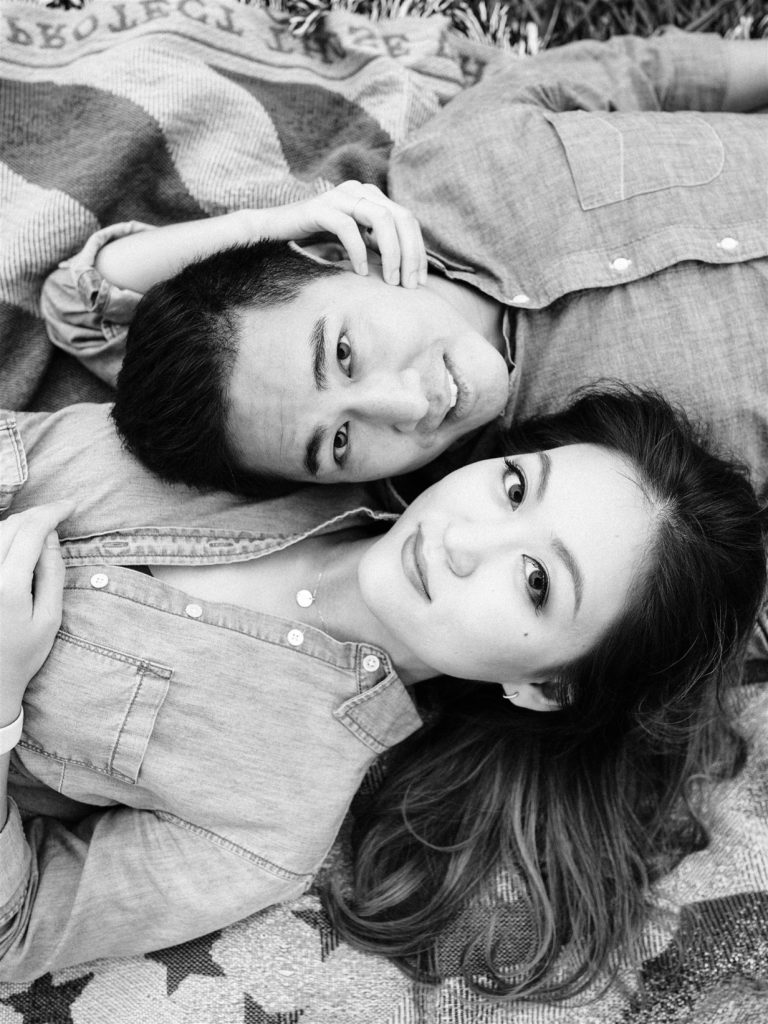engaged couple lay on blanket during fall engagement photos in VA