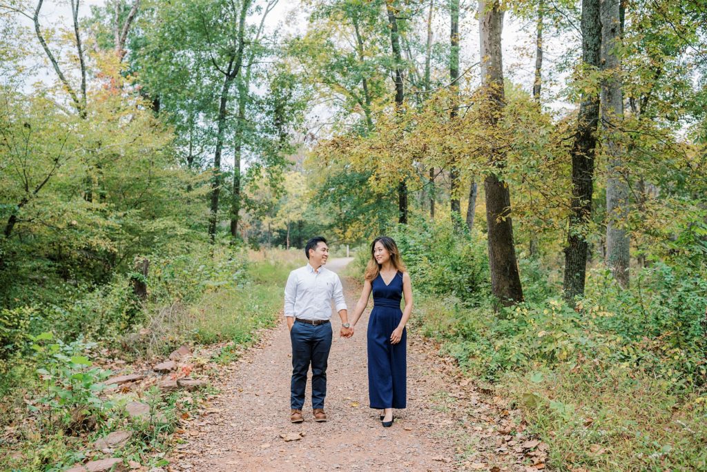 engaged couple walks through woods at Manassas Battlefield Park