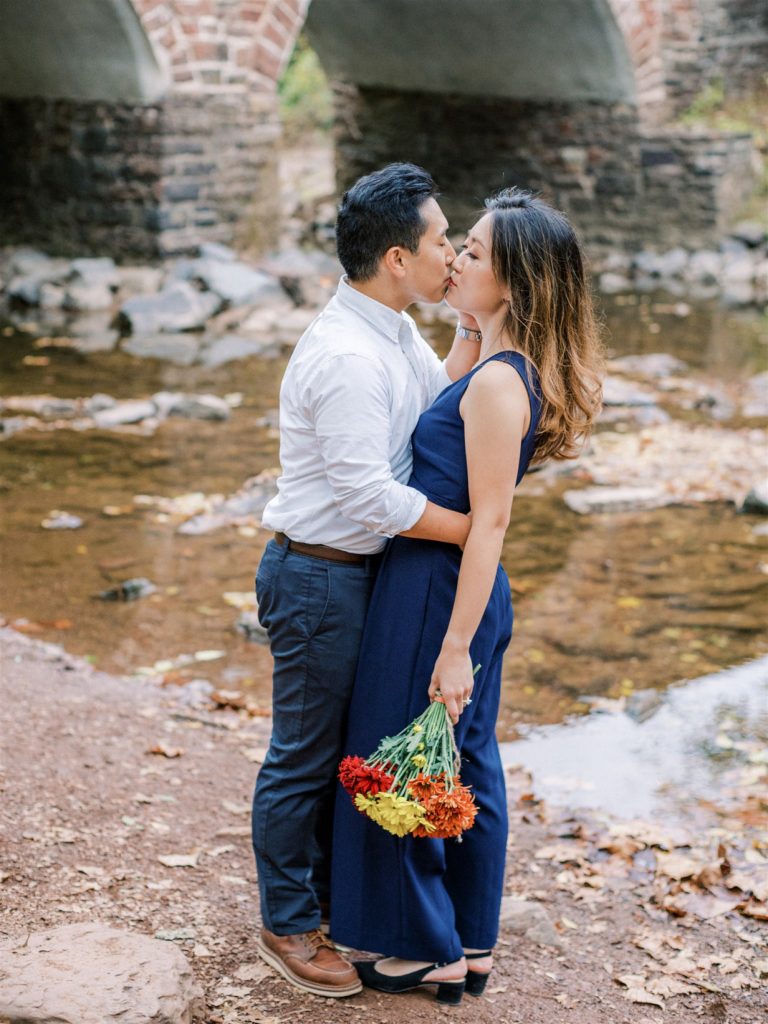bride and groom kiss standing by brick bridge at Manassas Battlefield Park