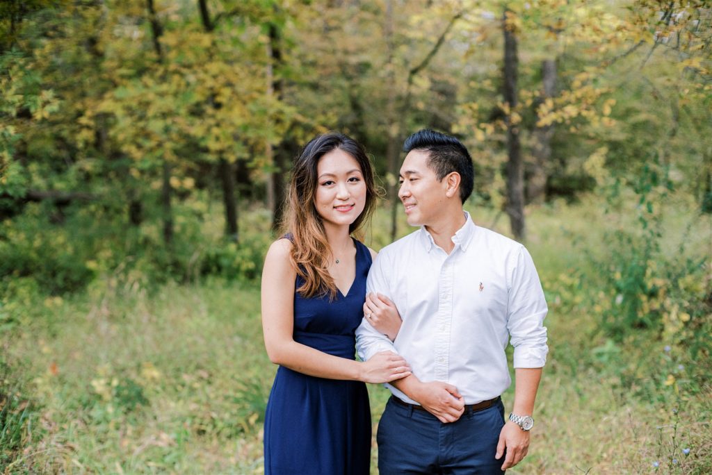 bride holds groom's arm during VA engagement photos