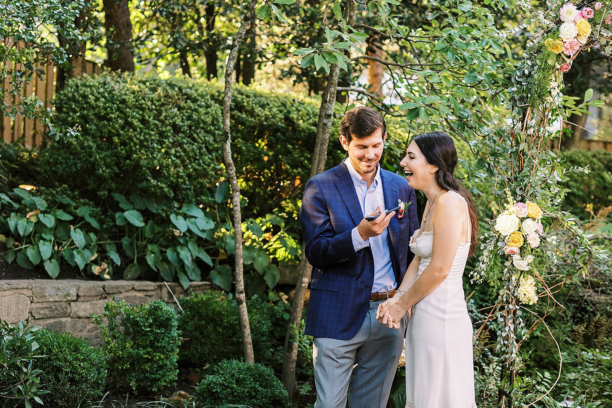 bride and groom laugh during wedding portraits in backyard 