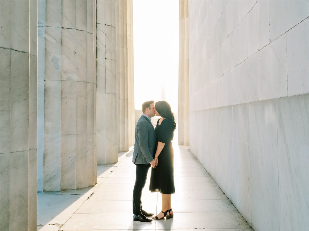 bride and groom kiss in columns of Lincoln Memorial