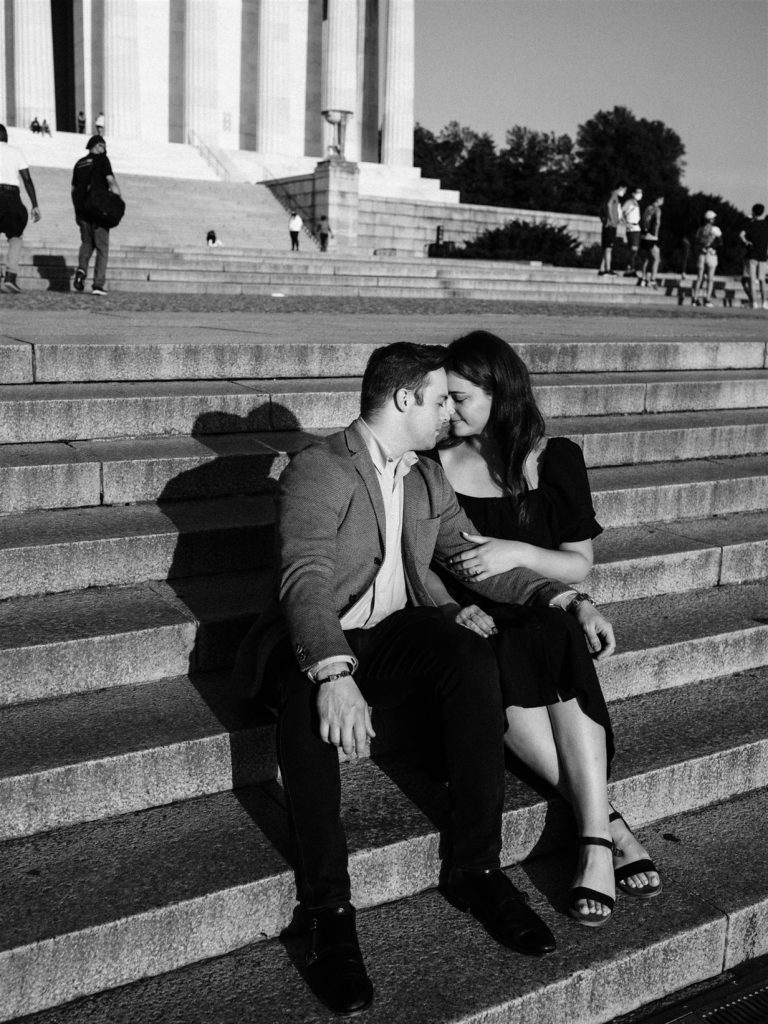 engaged couple sits on the steps of the Lincoln Memorial