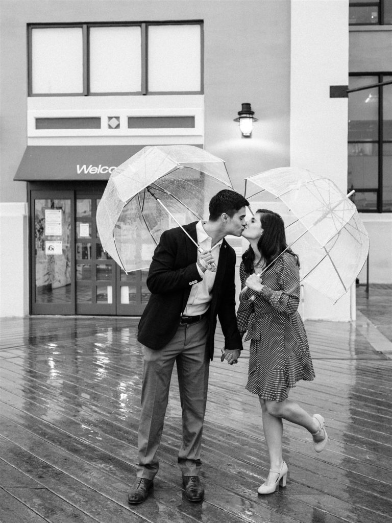 engaged couple kisses in the rain in Old Town Alexandria