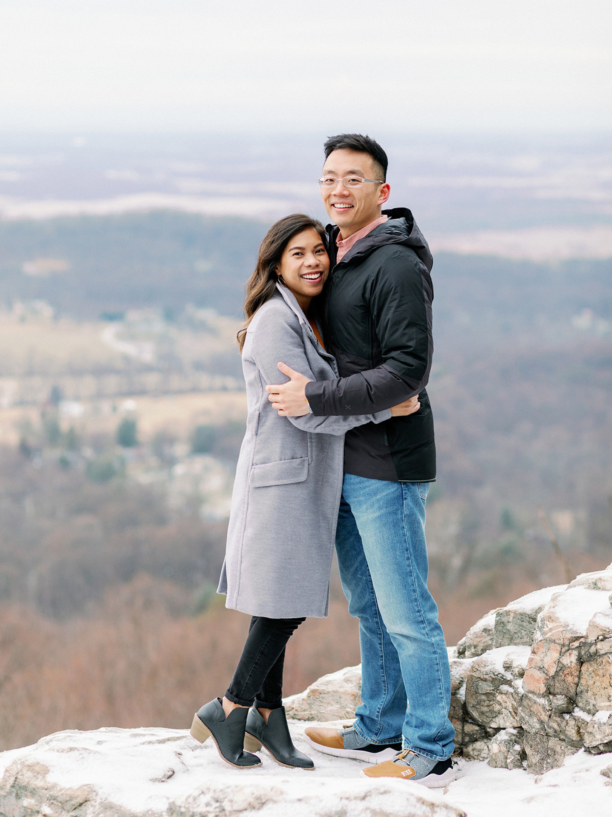 engaged couple hugs on top of Bear's Den during Snowy Engagement Session in Bluemont, VA 
