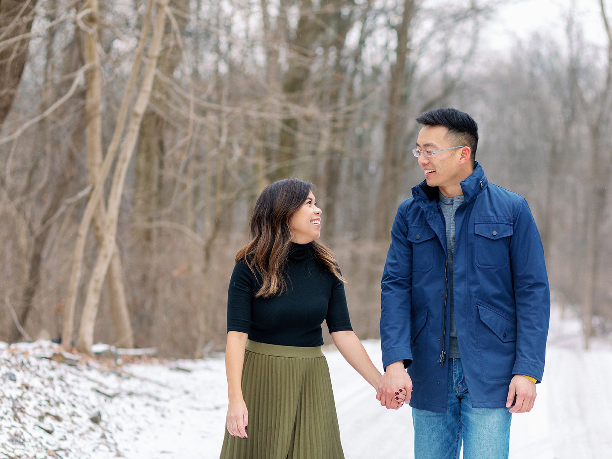 engaged couple walks through path during Snowy Engagement Session in Bluemont, VA 